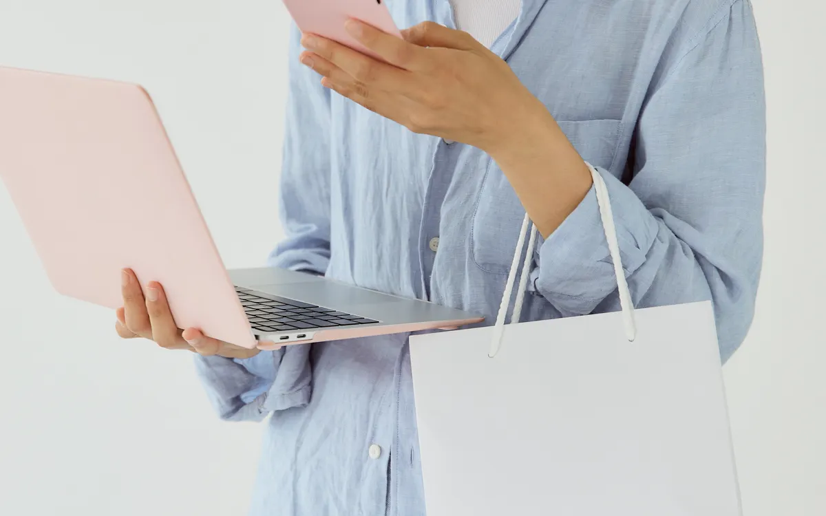 Persona utilizando un smartphone y un portátil para consultar contenido digital
