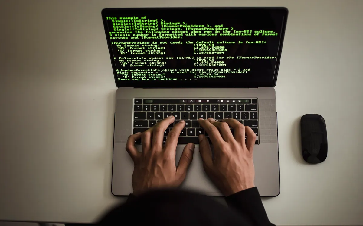 Persona trabajando con código en un ordenador portátil
