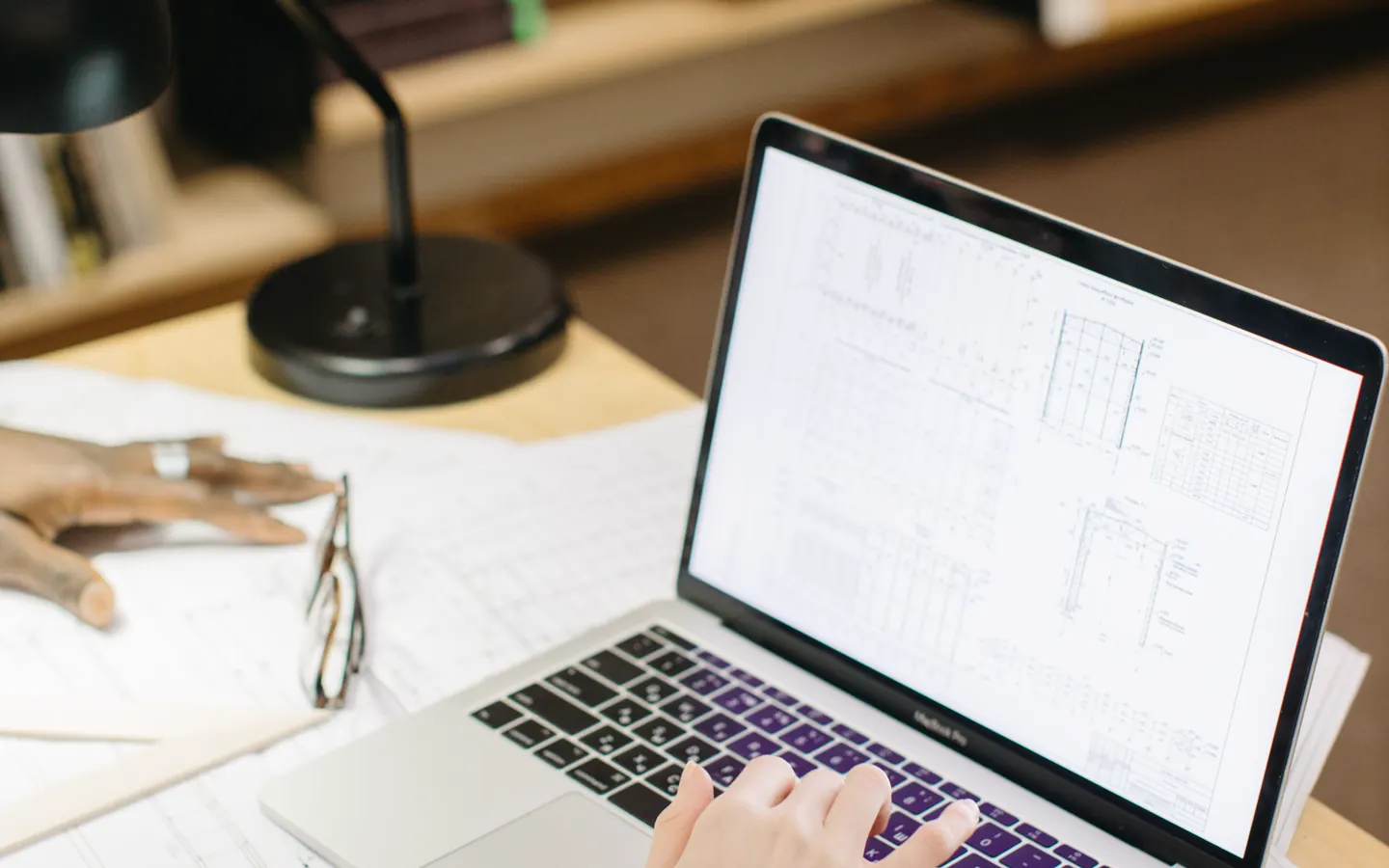 Ordenador portátil y planos sobre una mesa durante la planificación de un rediseño web