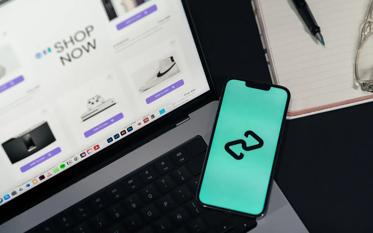 Portátil con una tienda online y smartphone sobre una mesa de trabajo