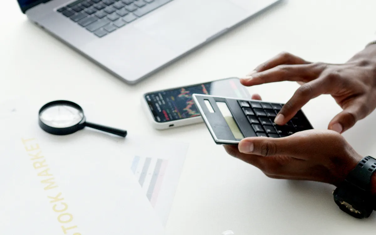 Persona analizando datos con un ordenador y una calculadora
