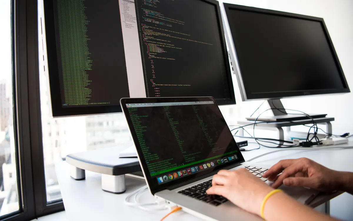 Diseñadora revisando una interfaz web en varias pantallas